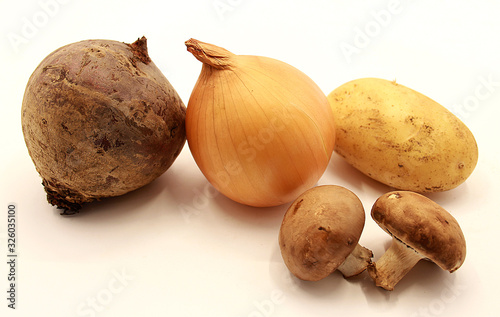 Vegetables: yellow onions, potatoes, beets and mushrooms isolated on white background