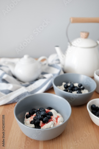 Tasty breakfast of Tvorog, farmers cheese, curd cheese or cottage cheese and blueberries in gray bowls. 