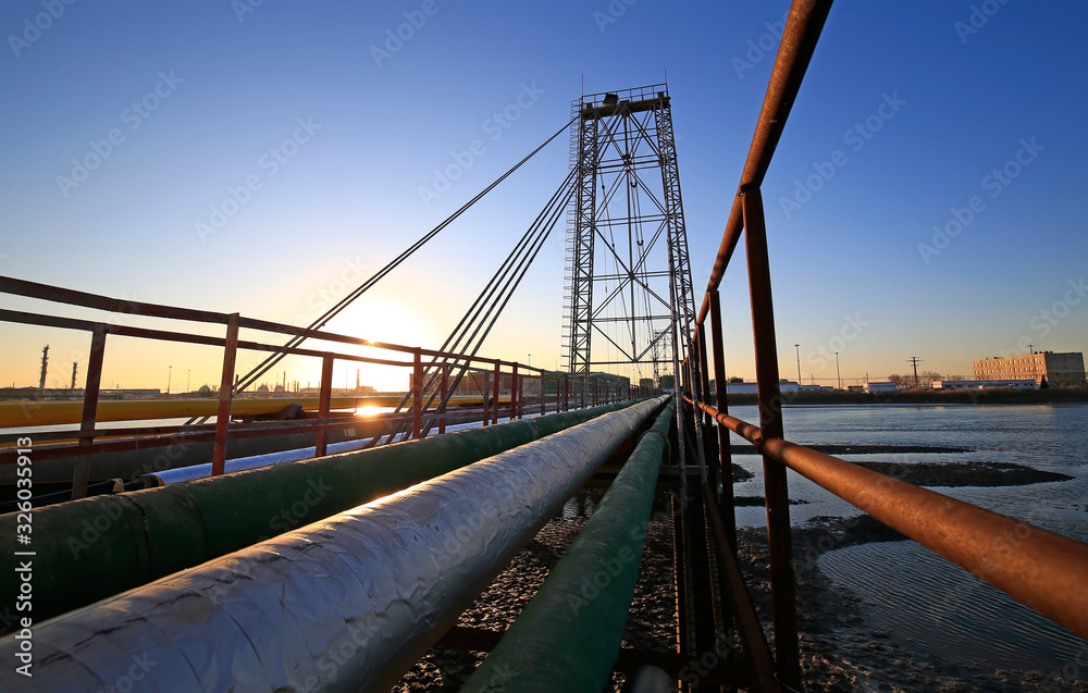The oil pipeline on the bridge, silhouetted in the sunset
