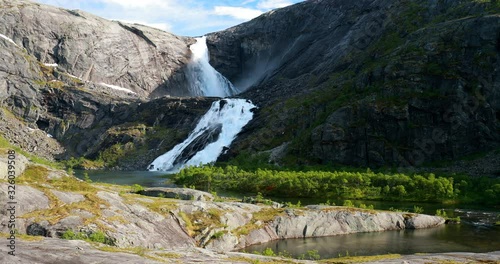 Kinsarvik, Hordaland, Norway. Waterfall Sotefossen In Hardangervidda Mountain Plateau. Famous Norwegian Landmark And Popular Destination In Spring Sunny Day photo