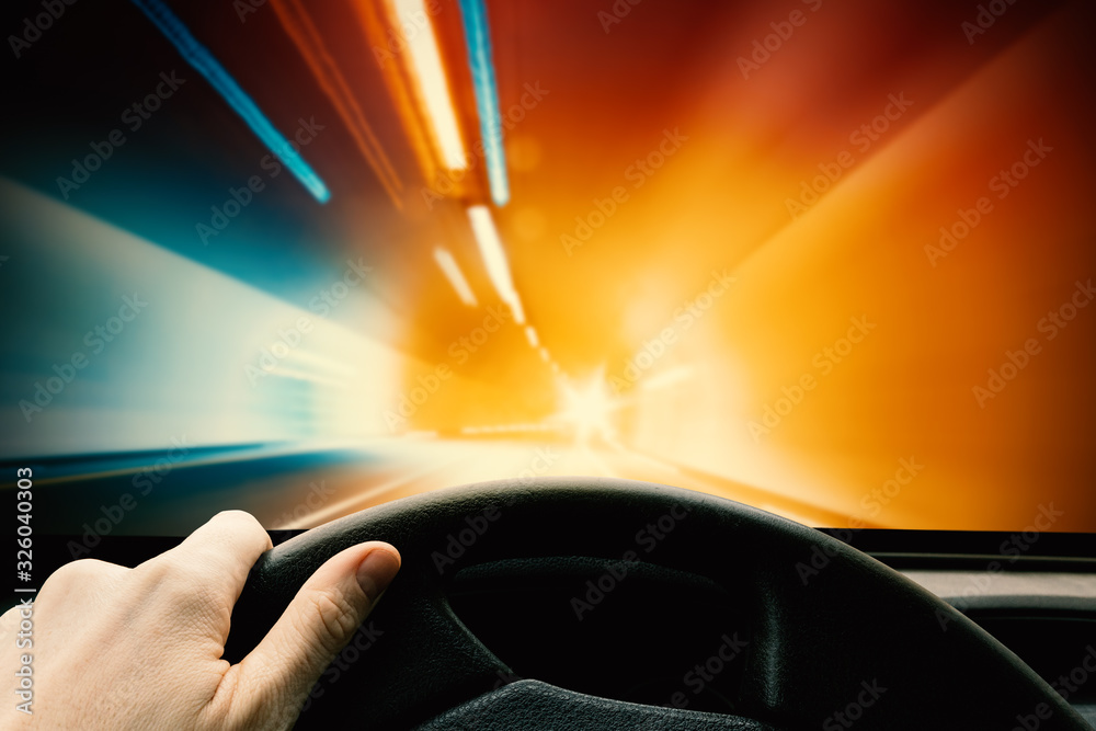 Obraz premium Hand on Steering Wheel - Driving Car in Tunnel. High Speed Concept, Blurred Motion Design.