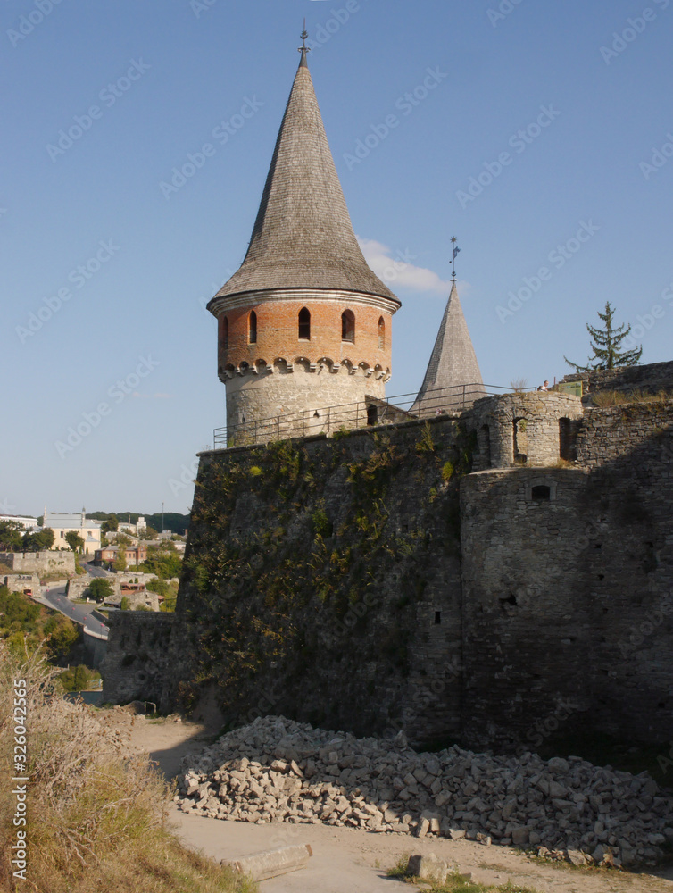 Medieval castle in the city of Kamyanets-Podilsky, Ukraine .  It is a formidable, strong fortress, whose walls are cut out of solid rock. The fortress stands at the top of a precipitous cliff . 