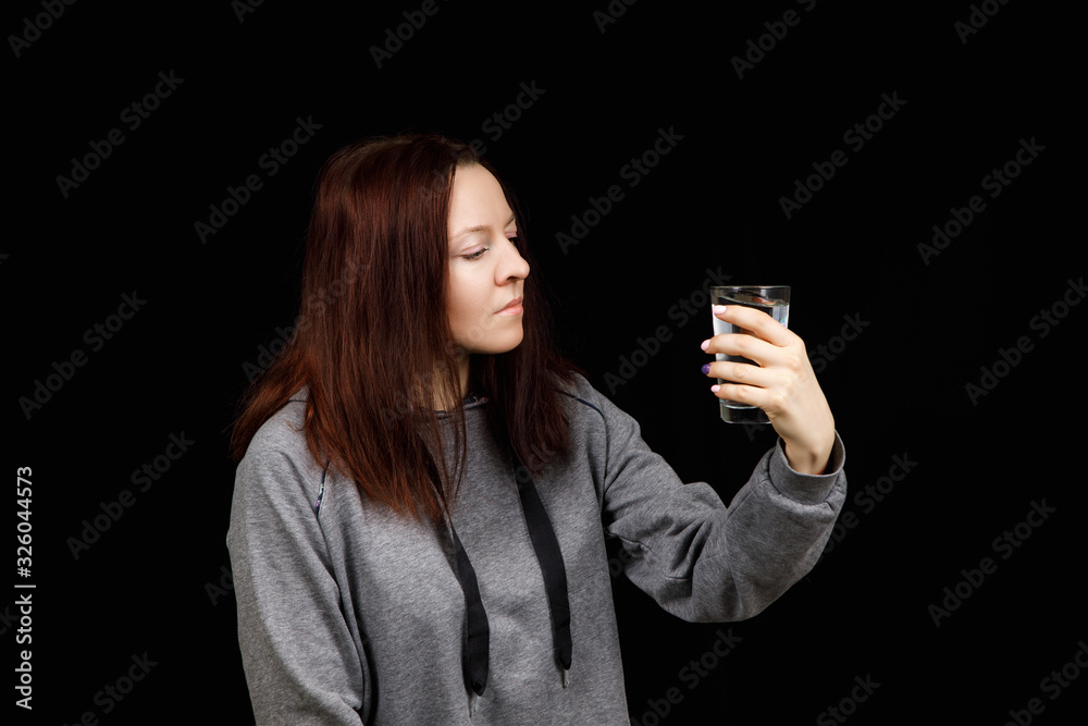 Portrait of a woman drinking water. Smiling girl. Portrait on a black background Portrait of a woman drinking water. Smiling girl. Portrait on a black background