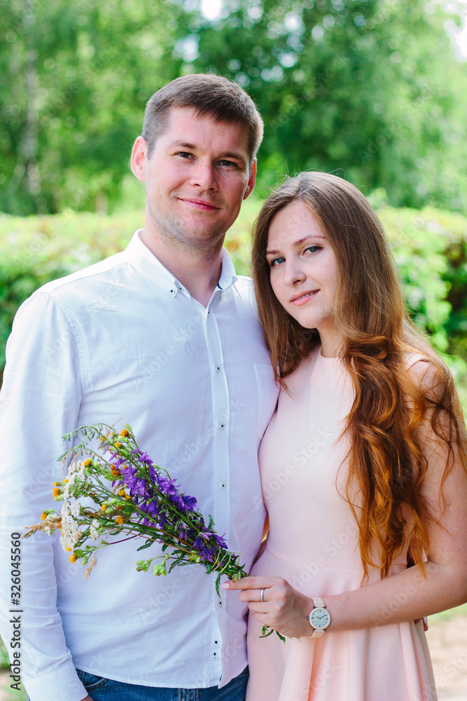 Young happy couple standing on the nature park