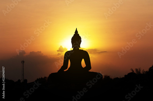 silhouette of buddha at sunset © khunnok studio