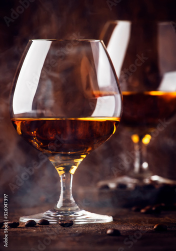 Armagnac, French grape brandy, strong alcoholic drink. Still life in vintage style with cigar smoke, copy space, toned