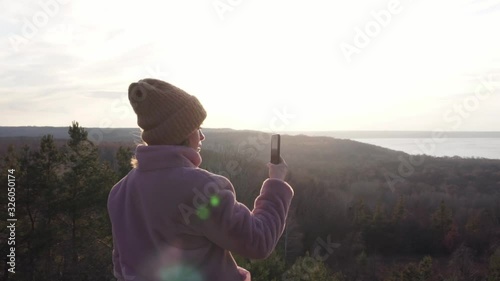 Young female recording a video with smartphone on mounting top