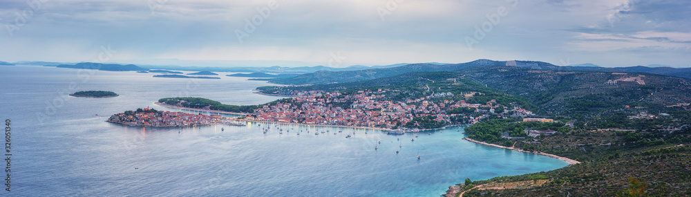 Aerial view of famous tourist sea resort Primosten and Adriatic seacoast at sunset, Dalmatia, Croatia. Scenic panoramic landscape with town, sea, islands and sky, outdoor travel background