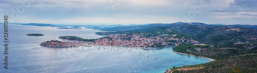 Aerial view of famous tourist sea resort Primosten and Adriatic seacoast at sunset, Dalmatia, Croatia. Scenic panoramic landscape with town, sea, islands and sky, outdoor travel background