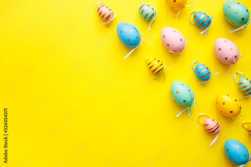 Easter colored eggs on yellow background. Happy Easter greeting card minimal concept. Top view, flat lay