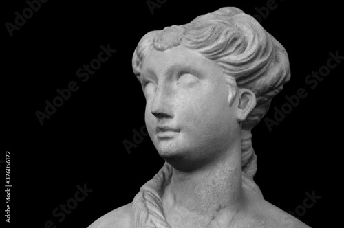 White marble sculpture head of young woman. Statue of sensual renaissance art era naked woman in circlet antique style isolated on black background