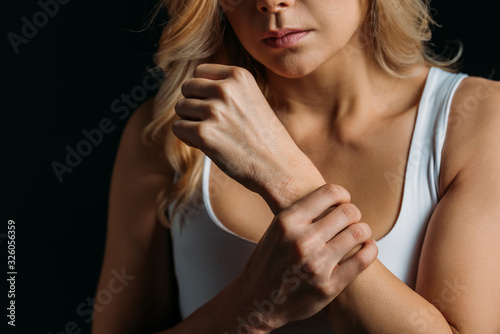 Cropped view of woman holding hand isolated on black