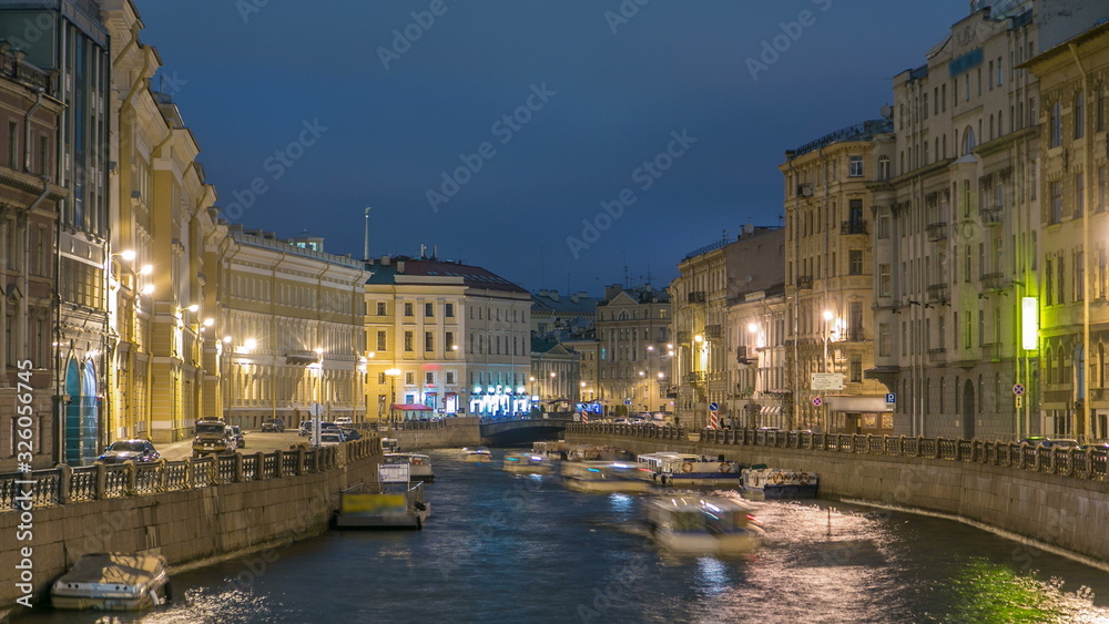 Moyka river timelapse in Saint Petersburg, Russia at night with a motion blurred touristic boat, illuminated old buildings.