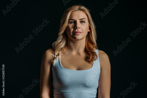 Front view of woman looking at camera isolated on black
