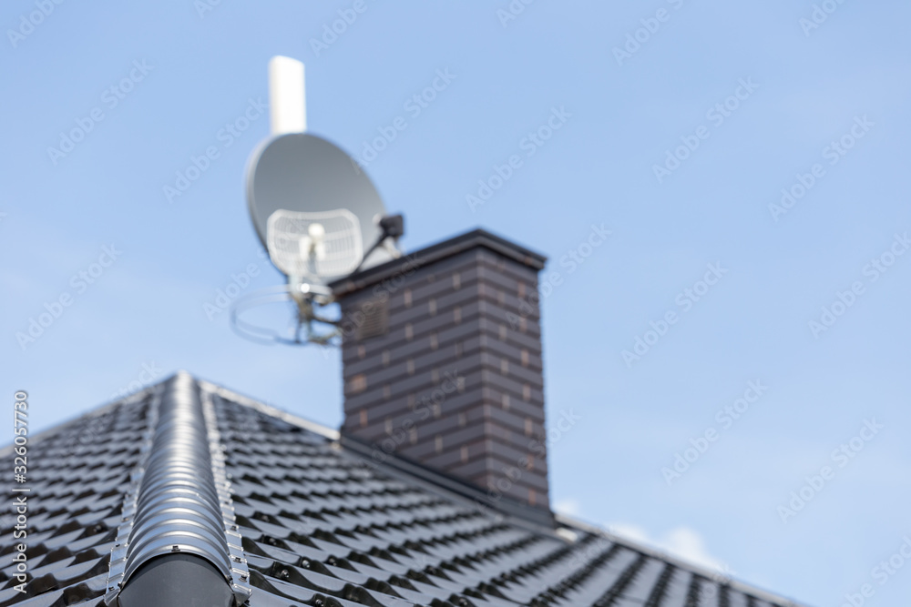 Obraz premium roof of the new modern house with ventilation chimney and satellite dish