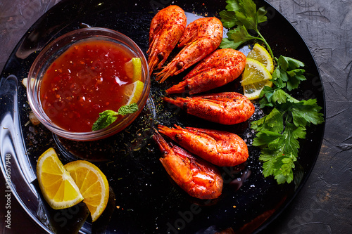 prawns fried with spices with sauce and lemon slices