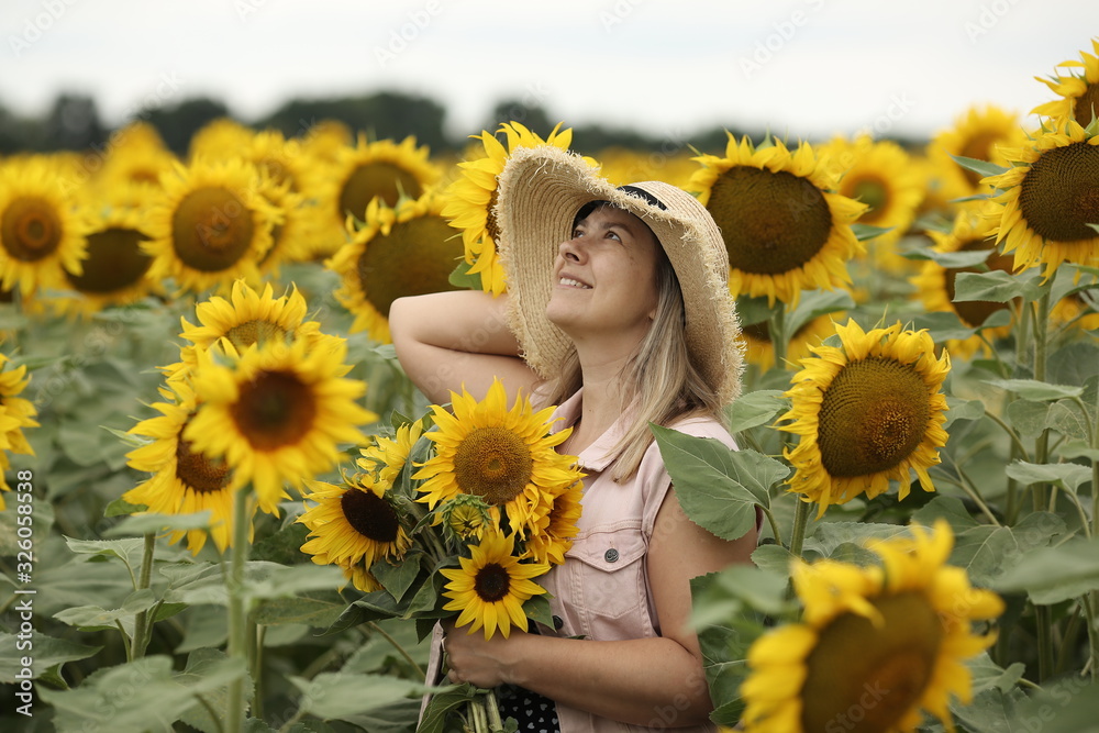 woman in a field with a bouquet of sunflowers and a straw hat, portrait woman in a field with a bouquet of sunflowers and a straw hat, portrait
