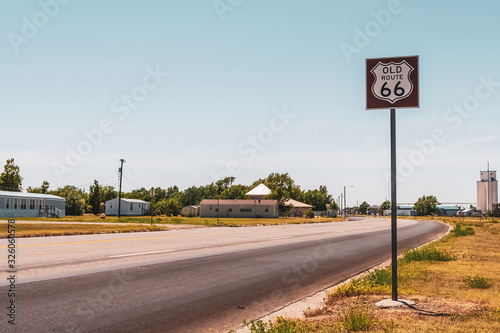 Historic old Route 66 signpost along the road on a beautiful day of summer, Vega, Texas, USA. Vintage look.