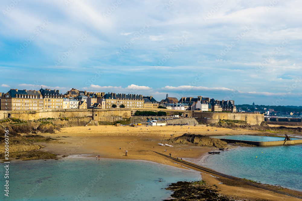 Saint Malo old town ramparts cityscape or skyline and Plage de Bon-Secours on a sunny day, Brittany, France. - obrazy, fototapety, plakaty 