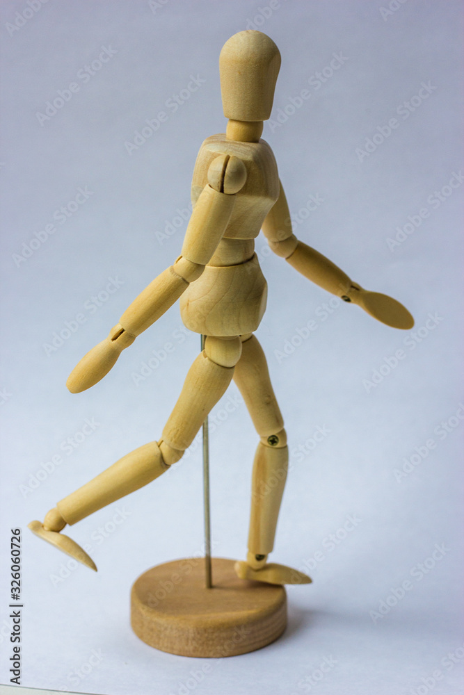 Wooden figure,isolated on white. Mannequin walks on white background Wooden figure,isolated on white. Mannequin walks on white background