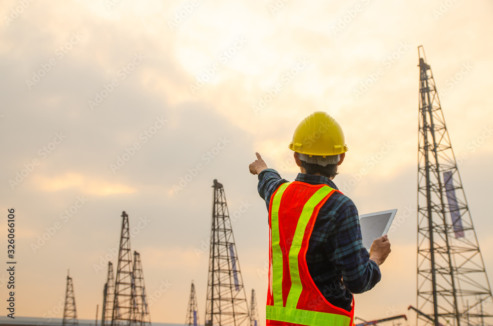 Construction engineer pointing the hand with the background of the construction site Construction engineer pointing the hand with the background of the construction site