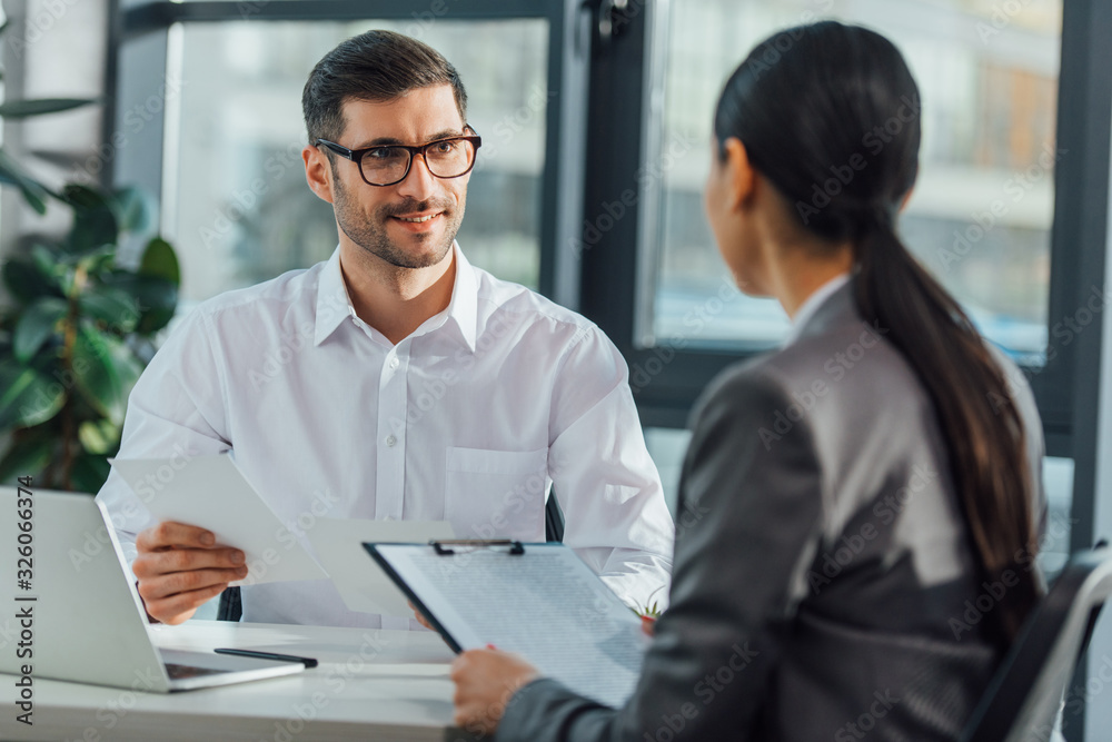 handsome male translator holding documents on meeting with businesswoman handsome male translator holding documents on meeting with businesswoman