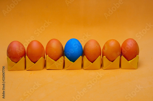 Painted easter eggs on origami stands in a row. Easter concept