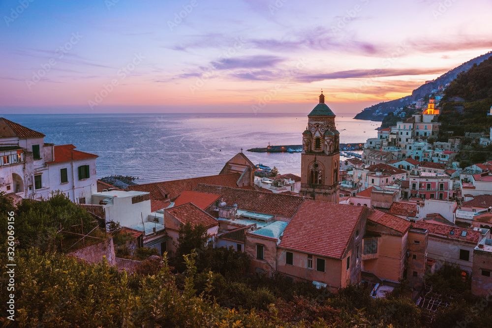 Obraz premium Beautiful view of the cathedral and the city of Amalfi with colorful houses at sunset. Amalfi evening panorama with sunset and sea views. Amalfi Coast, Italy