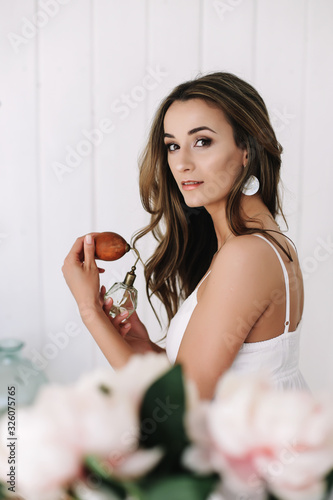 Portrait of a young beautiful woman. Bride in elegant classic wedding dress. Morning of the bride. Wedding preparations.