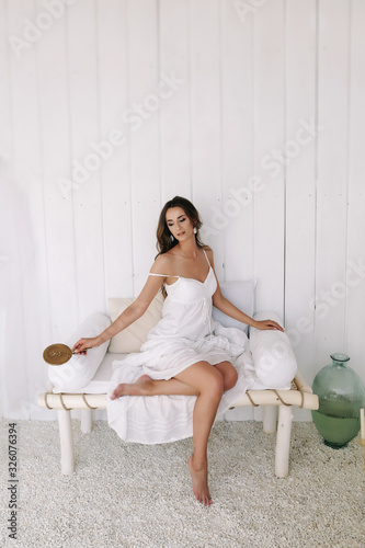 Portrait of a young beautiful woman. Bride in elegant classic wedding dress. Morning of the bride. Wedding preparations.
