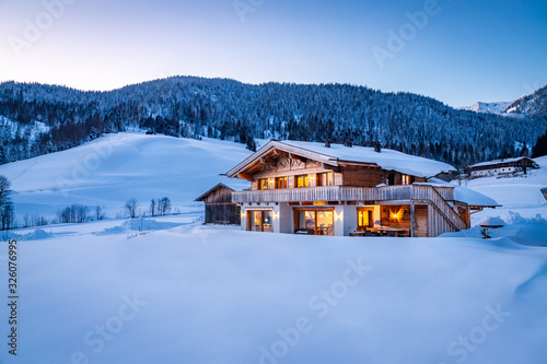 Wooden chalet in the alps on a cold winter evening Fototapete