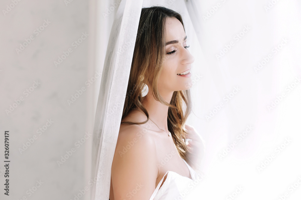 Portrait of a young beautiful woman. Bride in elegant classic wedding dress. Morning of the bride. Wedding preparations. Portrait of a young beautiful woman. Bride in elegant classic wedding dress. Morning of the bride. Wedding preparations.