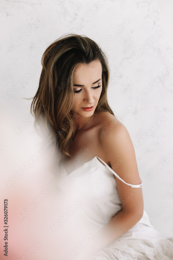 Naklejka premium Portrait of a young beautiful woman. Bride in elegant classic wedding dress. Morning of the bride. Wedding preparations.