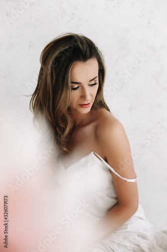 Portrait of a young beautiful woman. Bride in elegant classic wedding dress. Morning of the bride. Wedding preparations.