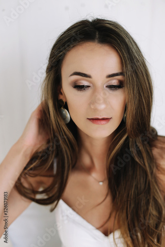 Portrait of a young beautiful woman. Bride in elegant classic wedding dress. Morning of the bride. Wedding preparations.