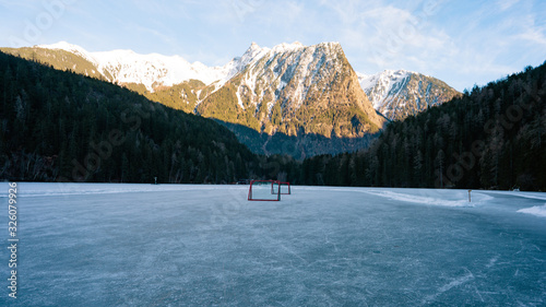 Natural hockey field. Wooden gates, for winter classic. The frozen lake Piburger See in the Oetztal, Austria with the Acherkogel in the background. photo