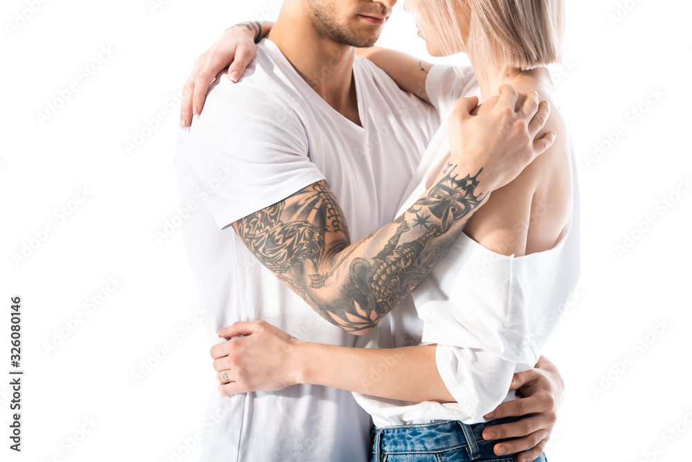 Naklejka premium cropped view of sexy young tattooed couple hugging isolated on white
