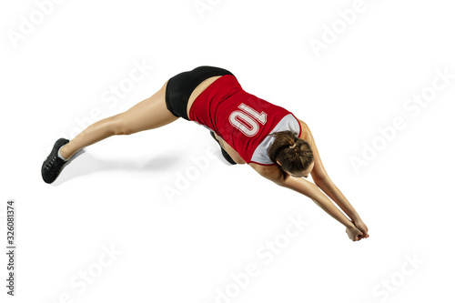 In jump and flight. Young female volleyball player isolated on white studio background. Woman in sportswear and sneakers training, playing. Concept of sport, healthy lifestyle, motion and movement.