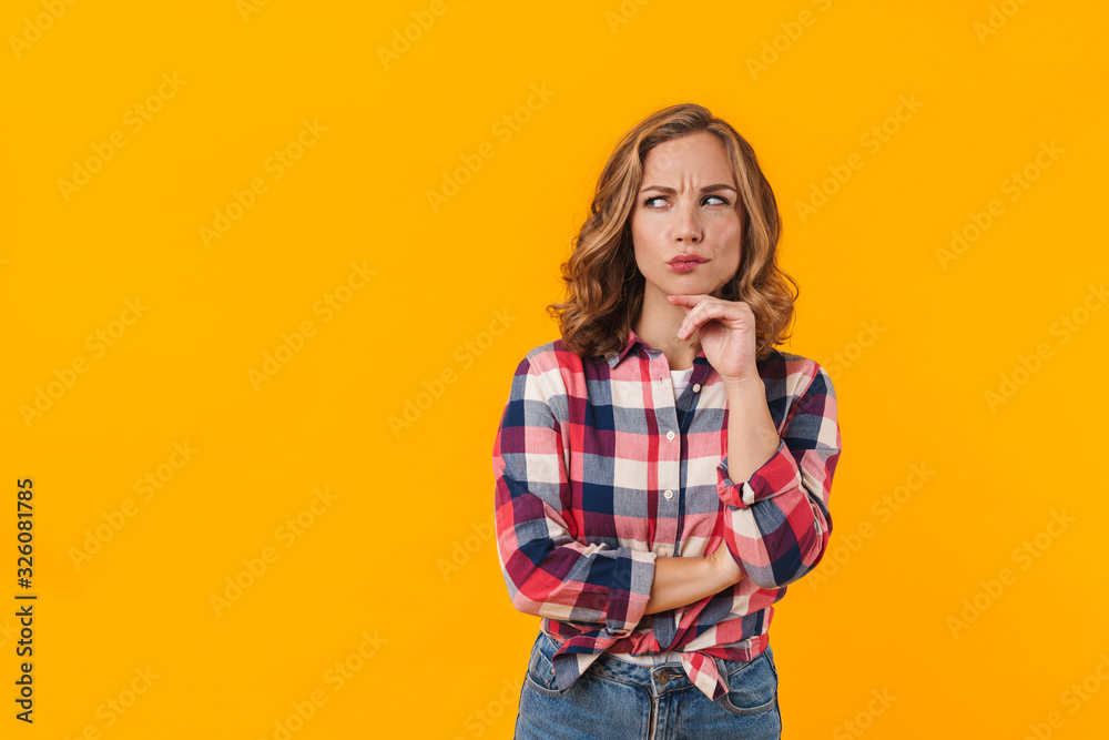 Image of young beautiful woman wearing plaid shirt expressing concern Image of young beautiful woman wearing plaid shirt expressing concern