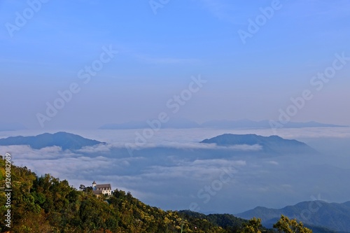 The gorgeous view of the fog moves along the mountains in the mountain range with big house on the mountain as foreground at Ba Na Hills, Da Nang, VIETNAM.