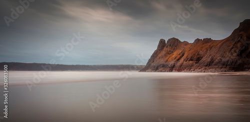 Low tide at the magnificent rocky outcrop called The Great Tor on Three Cliffs Bay, Gower, Swansea, UK
