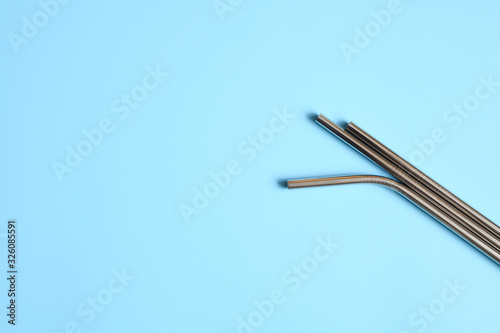 reusable metal stainless steel drinking straws on a blue background. space for text