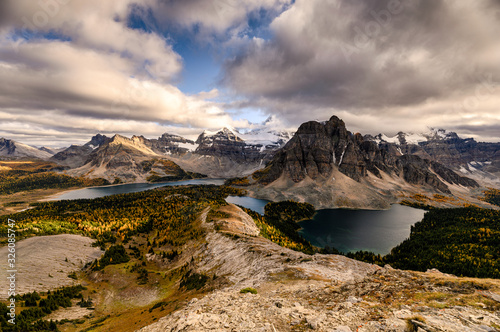 Mount Assiniboine with lake on Nublet peak in autumn forest on sunset at provincial park