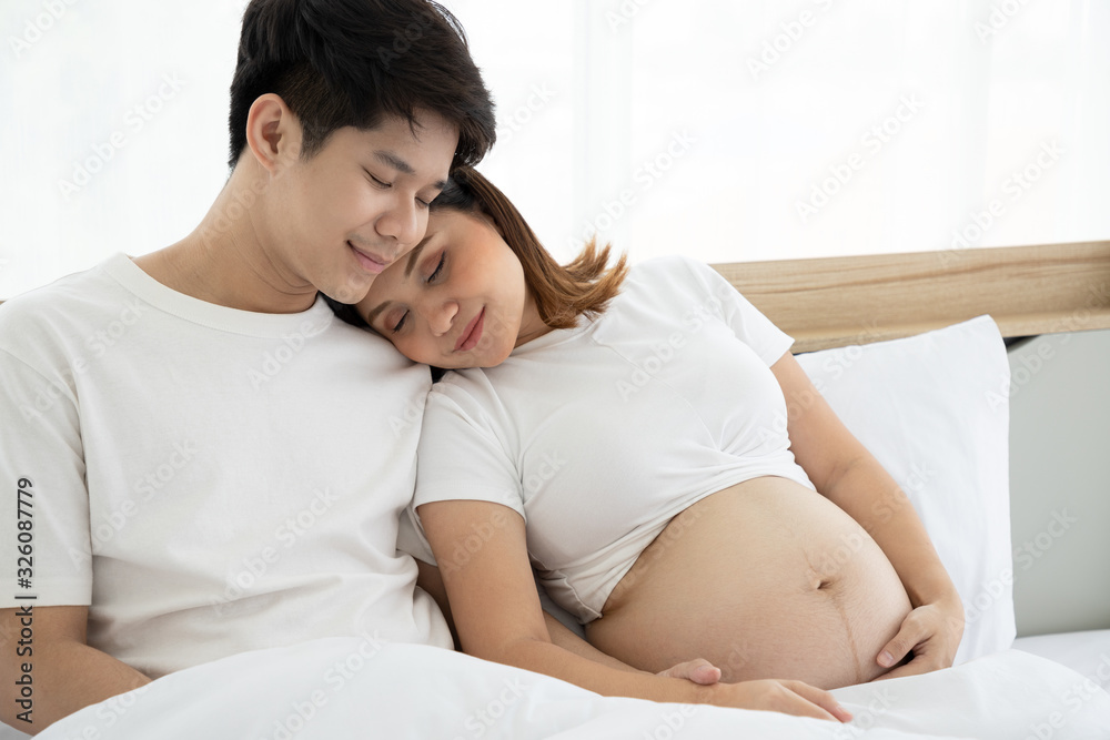 A handsome young husband and a beautiful wife, who are pregnant for about 6 months sleepless on bed. He takes care of her closely with love and cherish, with hugs and gentle touch. Being mother. A handsome young husband and a beautiful wife, who are pregnant for about 6 months sleepless on bed. He takes care of her closely with love and cherish, with hugs and gentle touch. Being mother.