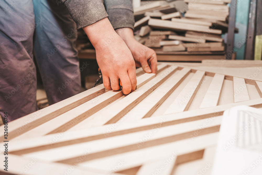 Carpenter measures plywood boards Carpenter measures plywood boards