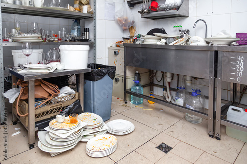 Metal sink full of dirty dishes, crockery, tableware