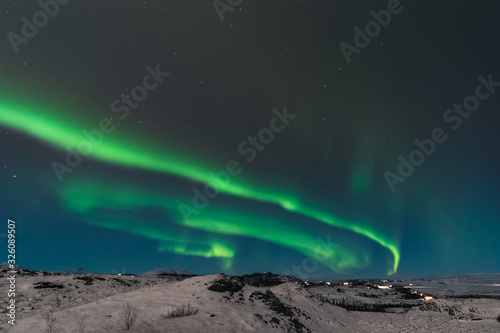 A beautiful northern lights also called Aurora Borealis over the Iceland. Winter time in Scandinavia is very magical and brings a lot of tourists from all over the world to see it