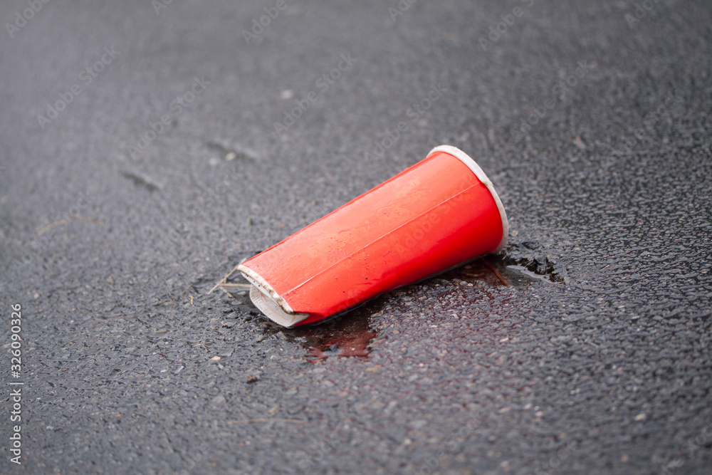 Crushed soda cup thrown on ground on asphalt road. Plastic wast destroying the planet. Crushed soda cup thrown on ground on asphalt road. Plastic wast destroying the planet.