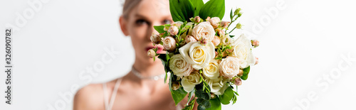 selective focus of beautiful tattooed bride and floral bouquet on white  panoramic shot