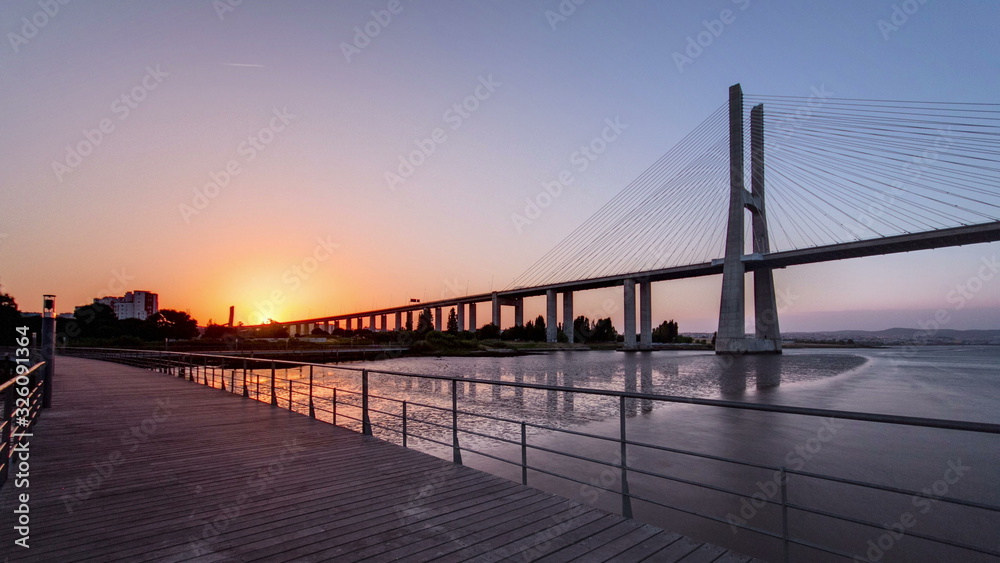 Vasco da Gama bridge during sunset and ebb-tide in Lisbon, Portugal. Timelapse